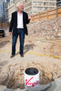 Richard Branson standing over Virgin branded Time capsule at construction site